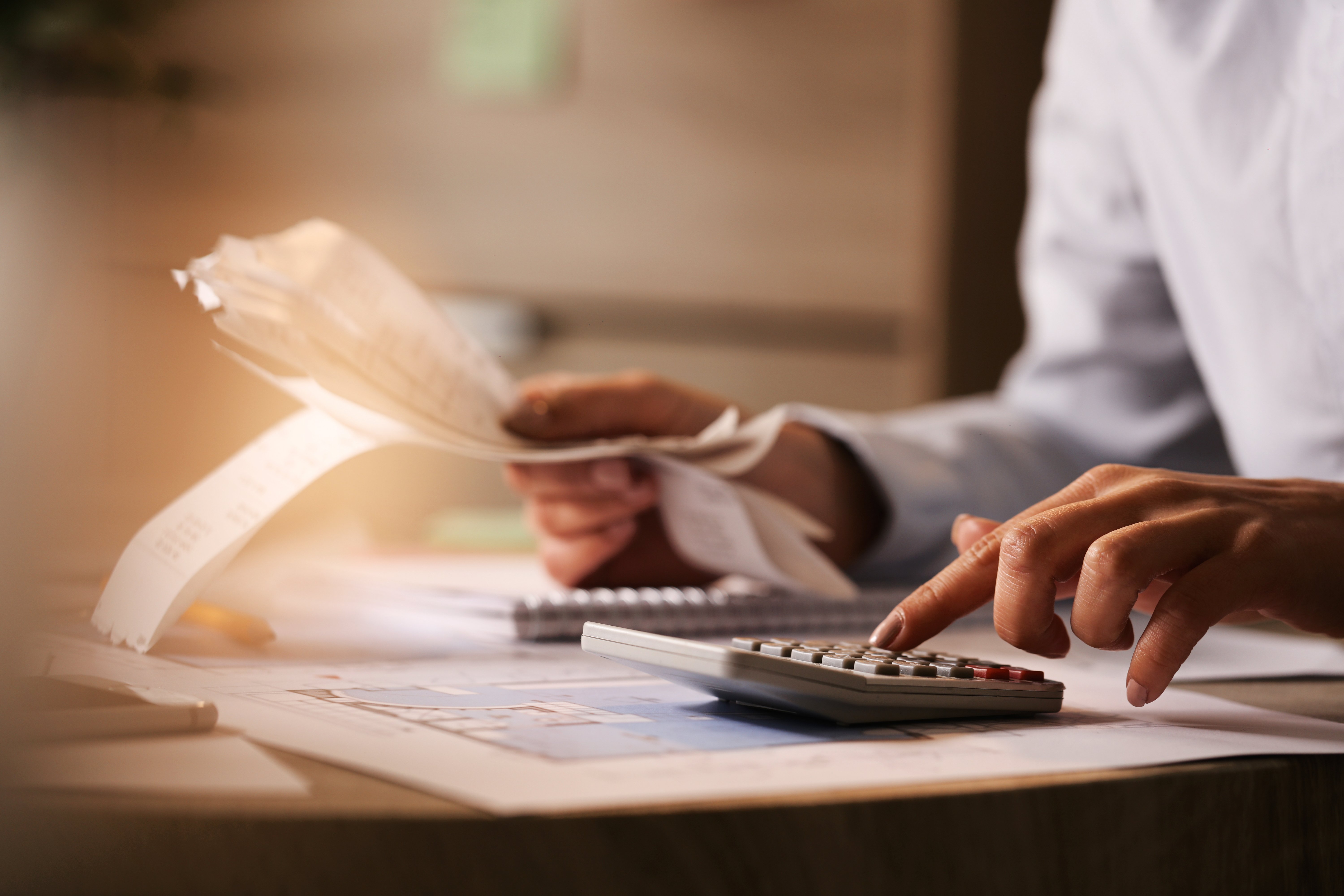 closeup-economist-using-calculator-while-going-through-bills-taxes-office_副本.jpg